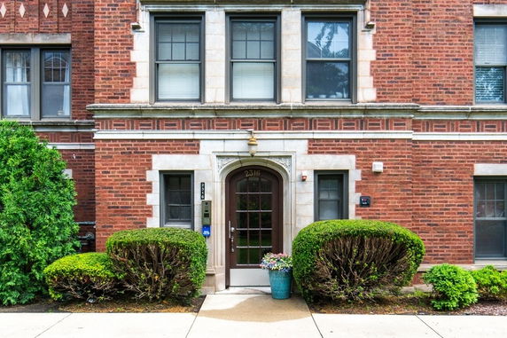 Front view of a brick building with a decorative entryway.