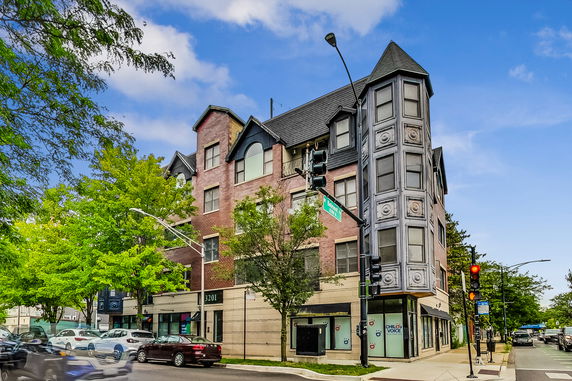 Front view of a multi-story building with a unique corner tower feature.