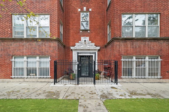 Front view of a brick residential building with decorative entrance.