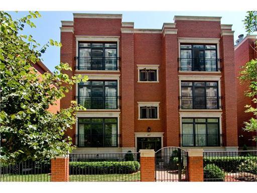 Front view of a multi-story brick building with large windows.
