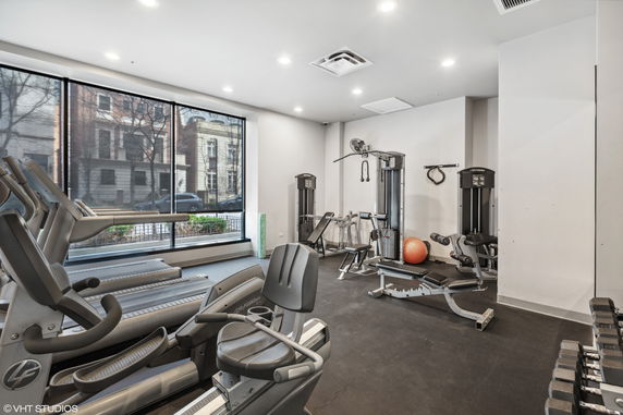 Indoor gym area with exercise equipment and large windows.