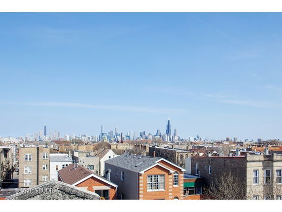 Panoramic view of a city skyline with houses in the foreground.