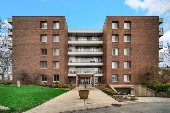 Front view of a multi-story residential building with a brick facade.