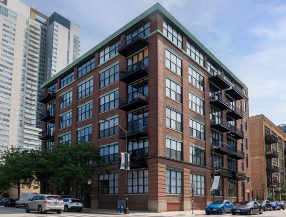Front view of a multi-story brick building with balconies.