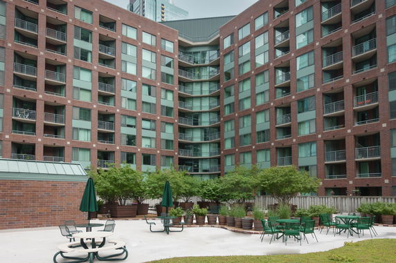 Front view of a multi-story brick apartment building with balconies.