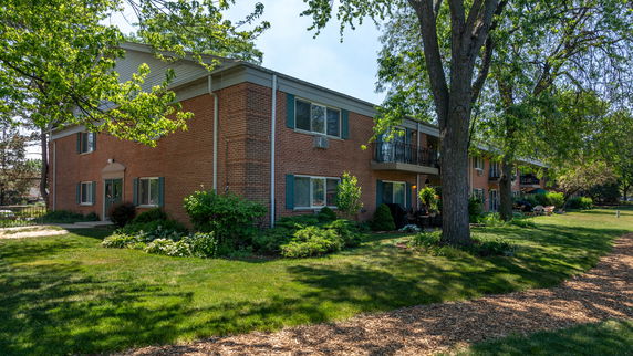 Front view of a two-story brick apartment building with balconies.