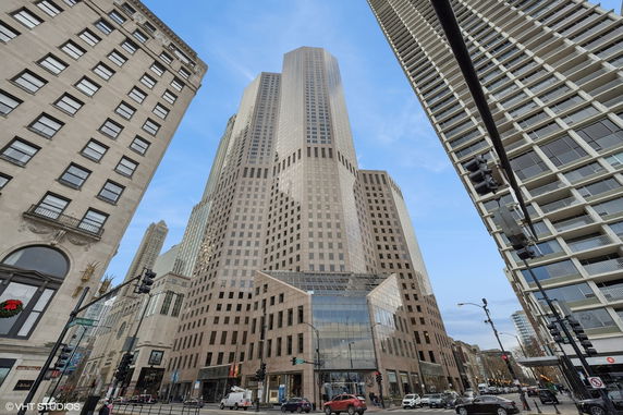 Front view of a tall skyscraper in an urban setting.