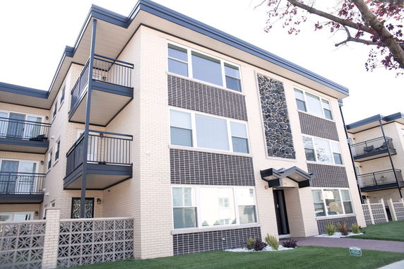 Front view of a three-story apartment building with balconies.