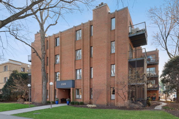 Front view of a multi-story brick building with balconies.
