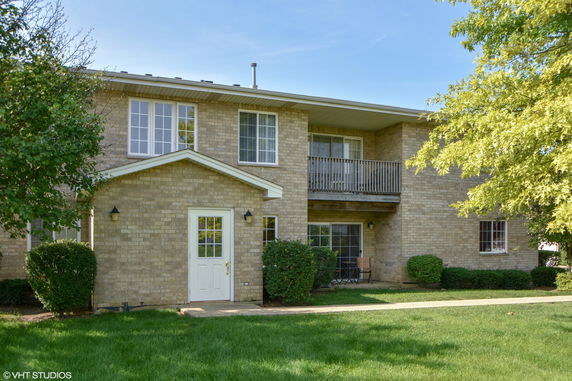 Front view of a two-story brick house with a balcony.