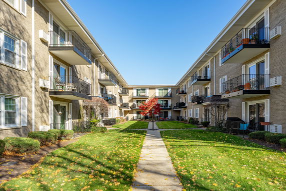 View of a multi-story apartment building with balconies and walkway.