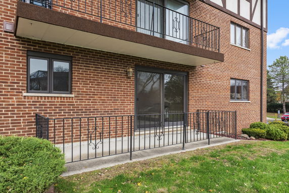 Front view of a brick building with balconies and large windows.