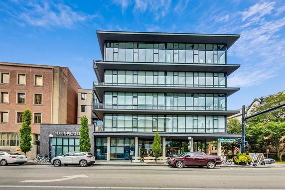 Front view of a multi-story building with large glass windows and balconies.