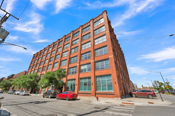 Front view of a multi-story brick building with large windows.