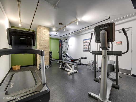 Indoor gym area with exercise equipment including treadmill and elliptical machines.