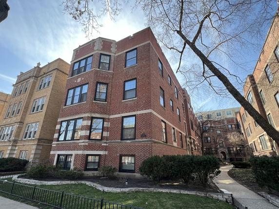 Front view of a multi-story brick apartment building.