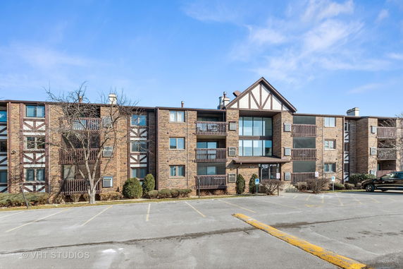 Front view of a multi-story apartment building with balconies.