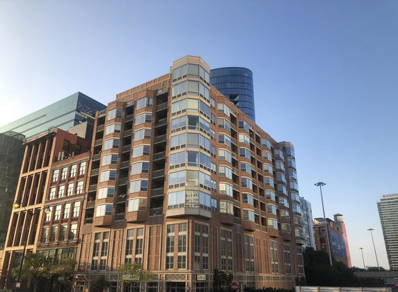 Front view of a multi-story building with large windows and brick façade.
