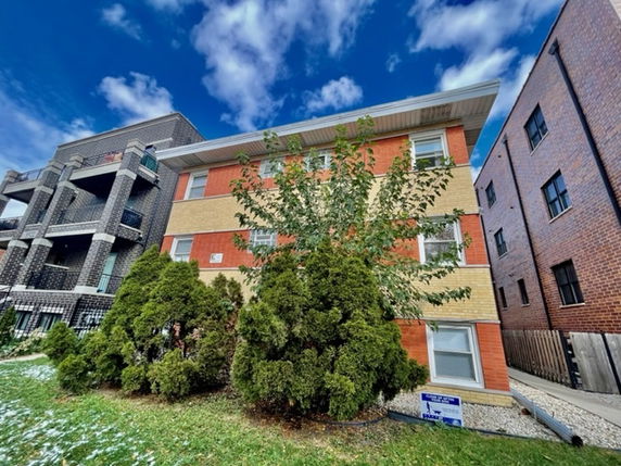 Front view of a multi-story brick apartment building.