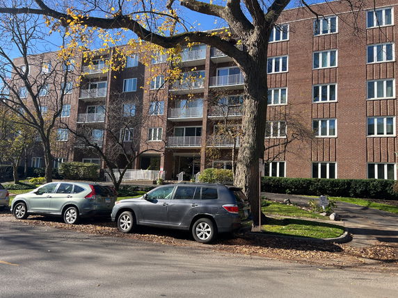 Front view of a multi-story residential building with brick facade and balconies.