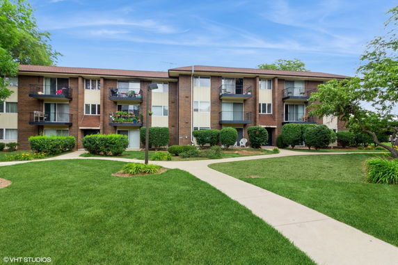 Front view of a three-story apartment building with balconies.