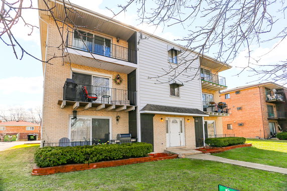 Front view of a multi-story residential building with balconies.