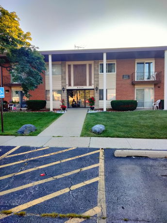 Front view of a mid-century apartment building with balconies.