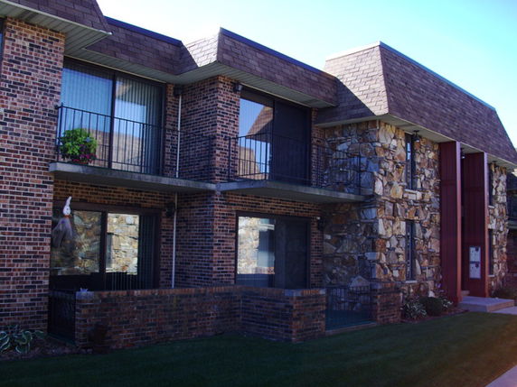 Front view of a two-story brick house with balconies.