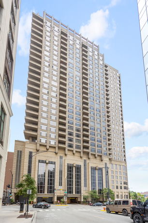 Front view of a high-rise building with numerous balconies and large windows.