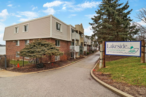 Front view of a multi-story condominium building with brick and siding exterior.