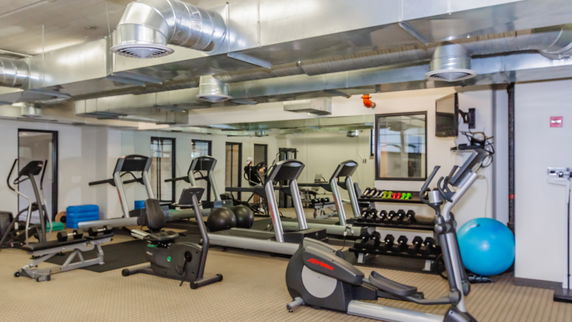 Indoor gym area with exercise equipment and mirrors.