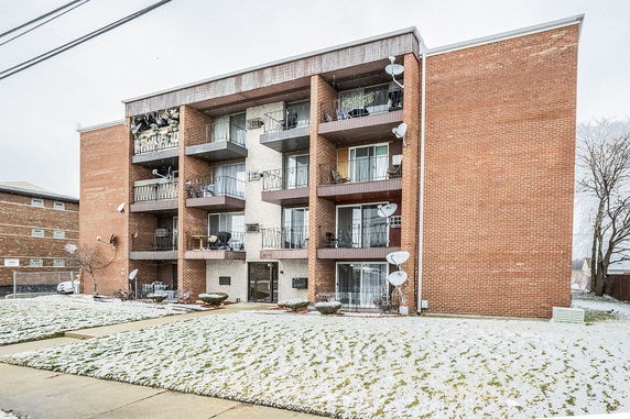 Front view of a multi-story apartment building with balconies.