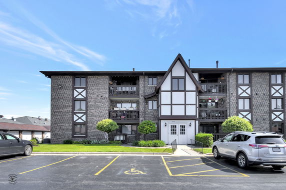 Front view of a multi-story apartment building with balconies.