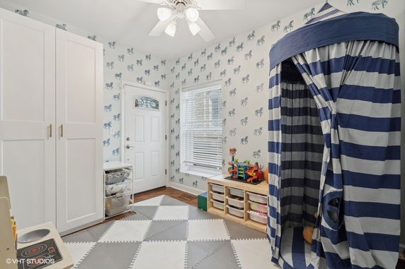 Room with play tent, toys, and storage cabinets.
