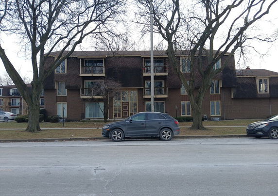 Front view of a multi-story residential building with balconies.