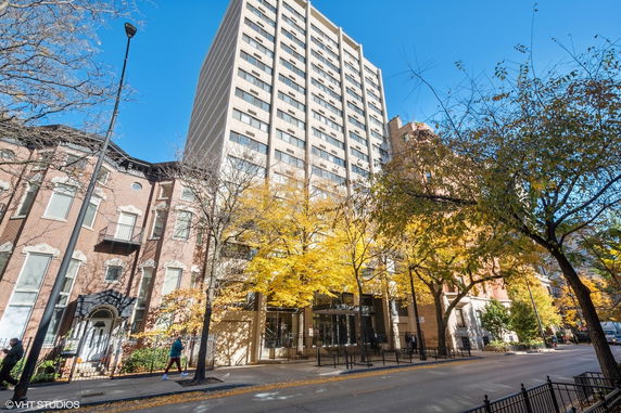Front view of a tall urban apartment building next to a street.