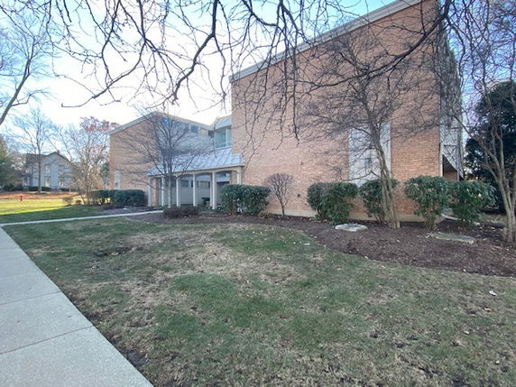 Front view of a brick building with large windows and a metal awning.