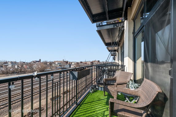 Balcony view overlooking rail tracks and distant urban skyline