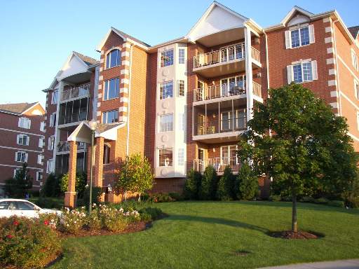 Front view of a multi-story residential building with balconies and brick exterior.