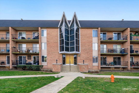 Front view of a multi-story residential building with balconies.