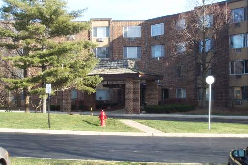 Front view of a multi-story brick building with an entrance canopy.