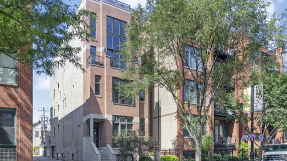 Front view of a multi-story brick building with large windows