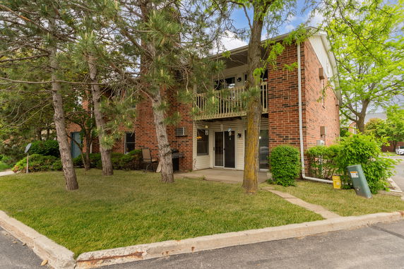 Front view of a two-story brick apartment building with balconies.