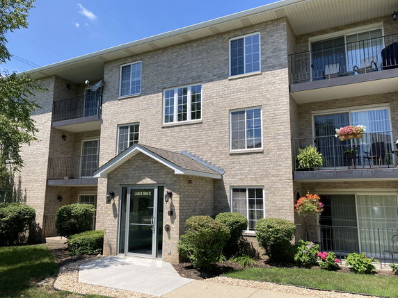 Front view of a three-story apartment building with balconies.