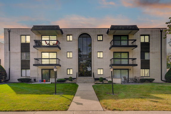 Front view of a multistory apartment building with balconies.