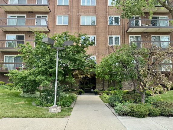 Front view of a multi-story brick building with balconies.
