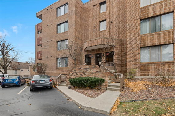 Front view of a multi-story brick building with a staircase entrance.