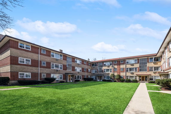 Front view of a multi-story brick apartment building.
