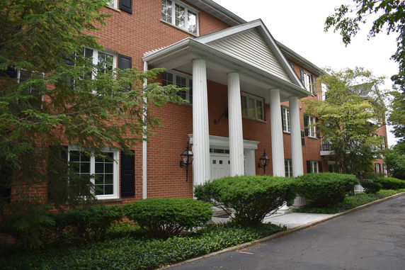 Front view of a multi-story brick building with white pillars at the entrance.
