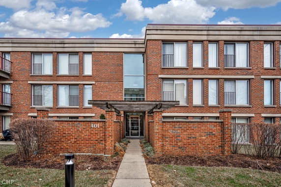 Front view of a multi-story brick building with large windows.